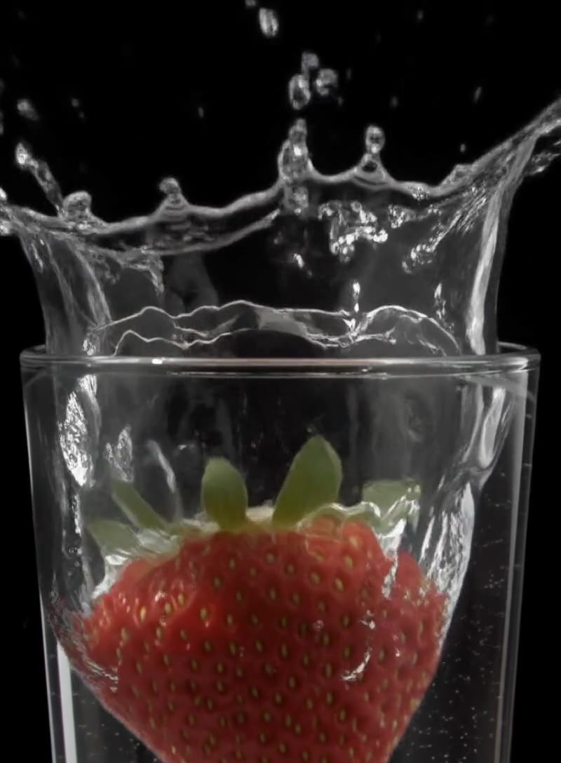 Strawberry splashing into a glass of water