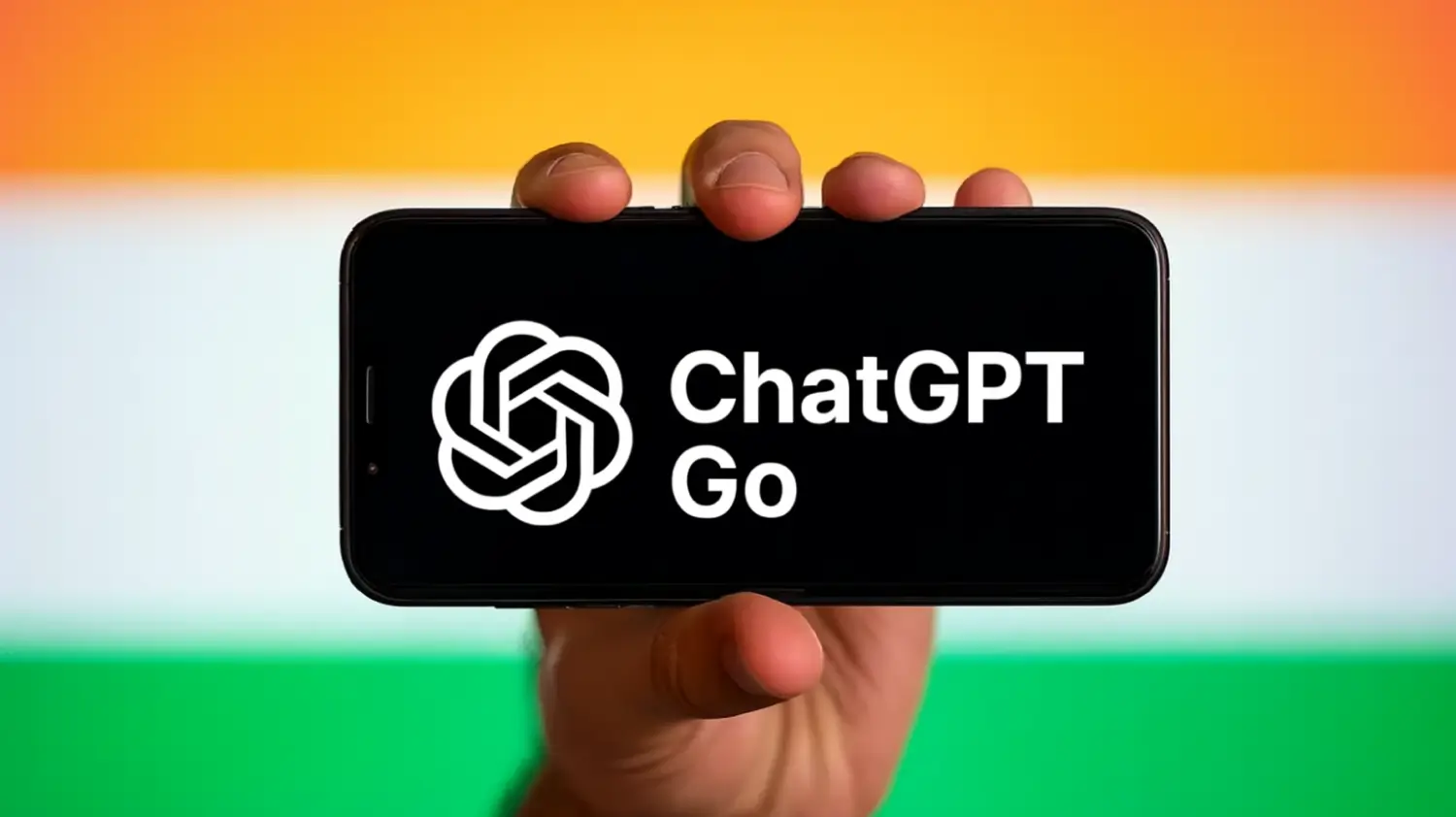 A person holding a smartphone with the text “ChatGPT Go” and the ChatGPT logo displayed on the screen, against the backdrop of the Indian flag with saffron, white, and green stripes.