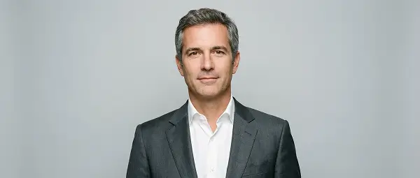 Professional headshot of a man in formal suit with clean studio background