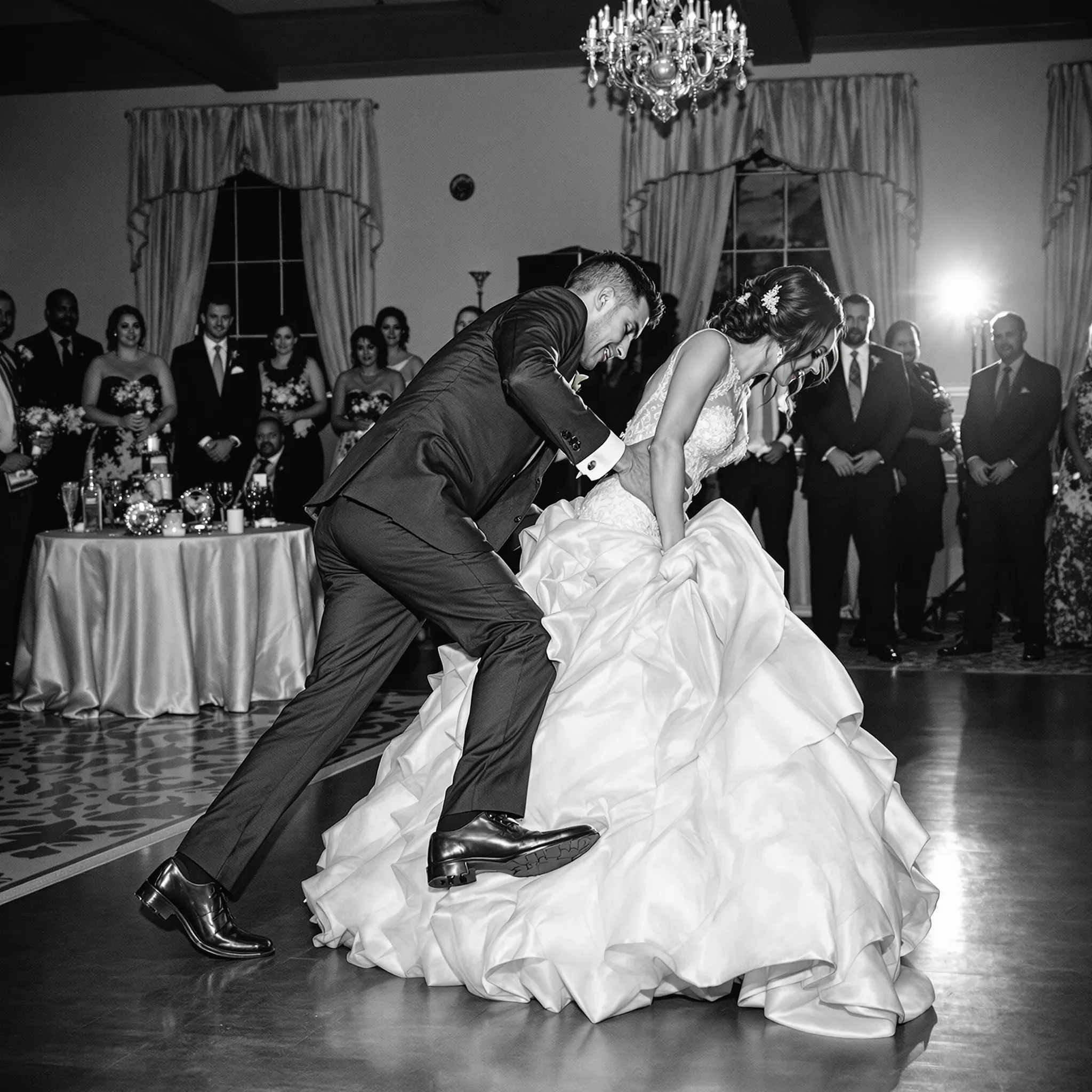 A black and white photo of a bride and groom dancing at their wedding reception.